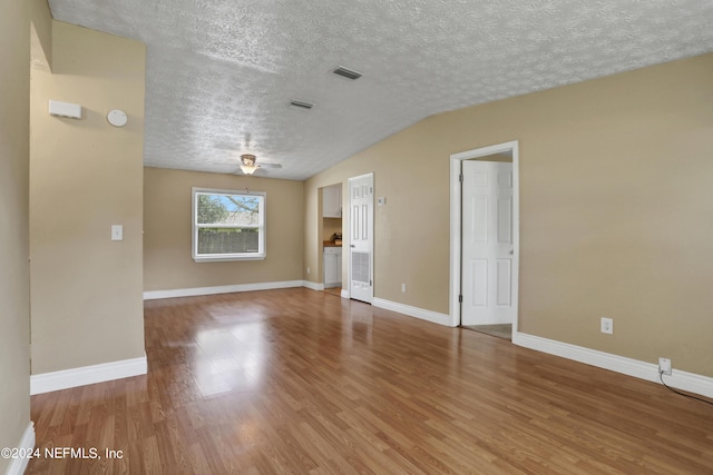 spare room featuring hardwood / wood-style flooring, lofted ceiling, a textured ceiling, and ceiling fan