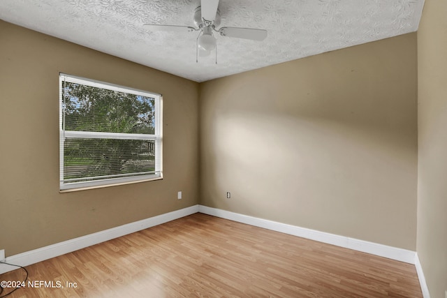 unfurnished room with ceiling fan, light hardwood / wood-style flooring, and a textured ceiling