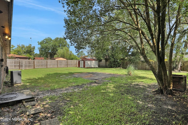 view of yard featuring a shed and central AC unit