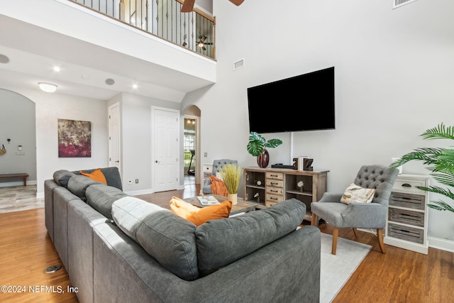 living room featuring hardwood / wood-style floors and a towering ceiling