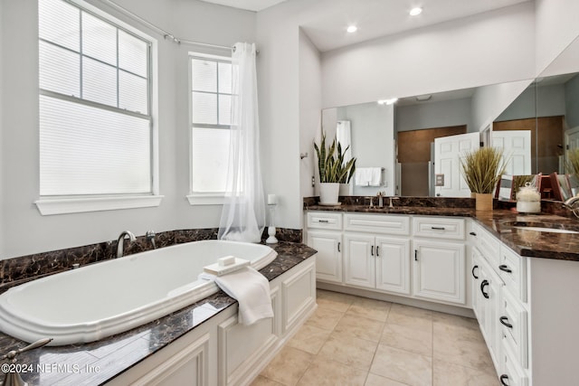 bathroom featuring vanity, a bathing tub, and tile patterned flooring