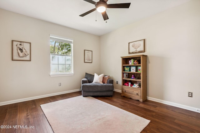 sitting room featuring dark wood-type flooring and ceiling fan