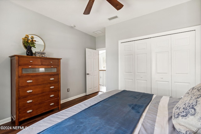 bedroom with dark wood-type flooring, ceiling fan, and a closet