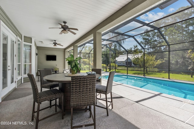 view of pool featuring ceiling fan, glass enclosure, and a patio area