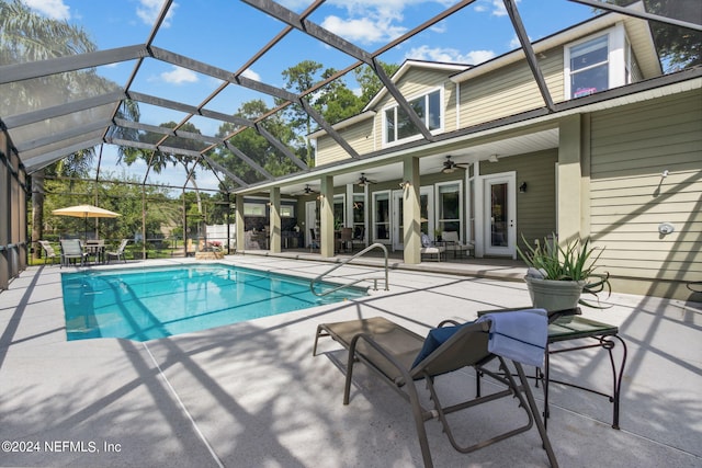 view of swimming pool with a patio area, ceiling fan, and glass enclosure