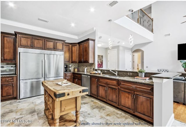 kitchen featuring tasteful backsplash, sink, dark stone countertops, stainless steel appliances, and crown molding