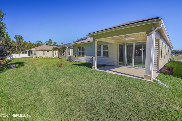 rear view of property featuring a yard, ceiling fan, and a patio area