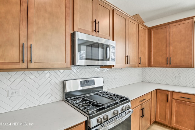 kitchen with tasteful backsplash and appliances with stainless steel finishes