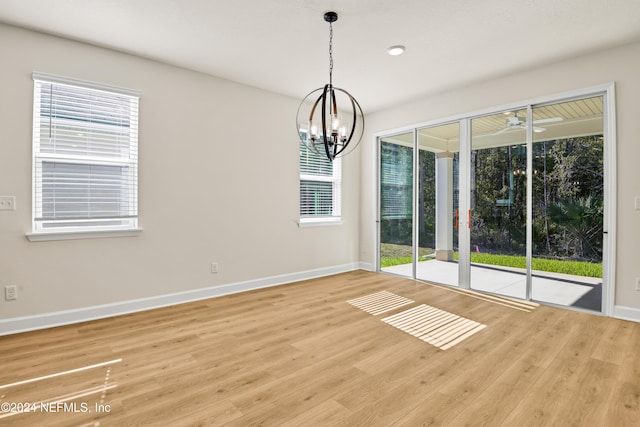 empty room featuring wood-type flooring and a chandelier