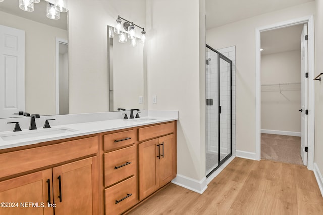 bathroom with vanity, hardwood / wood-style floors, and a shower with shower door