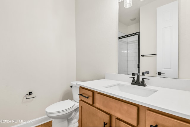 bathroom with vanity, toilet, and tiled shower