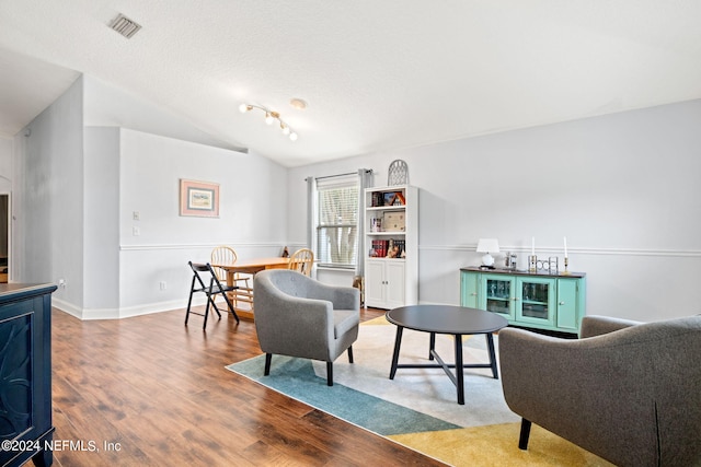 interior space with lofted ceiling, hardwood / wood-style flooring, and a textured ceiling