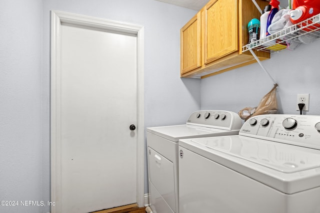 laundry area featuring washer and clothes dryer and cabinets