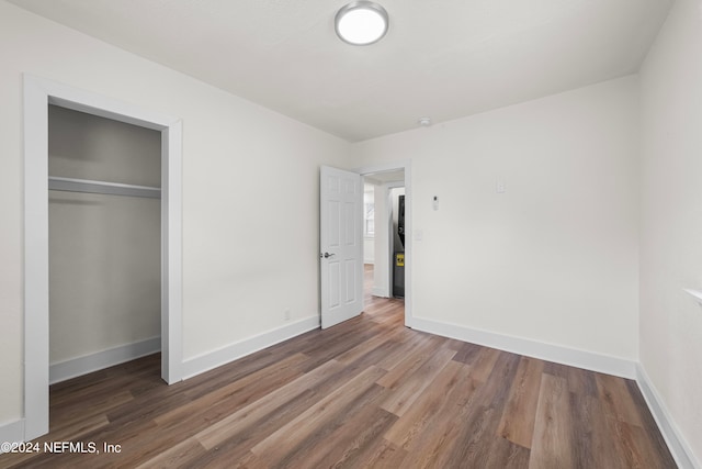 unfurnished bedroom featuring a closet and hardwood / wood-style floors