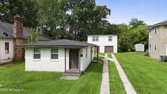 rear view of house featuring a shed, a garage, and a lawn