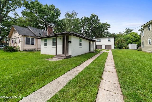 rear view of property with a yard and a storage unit