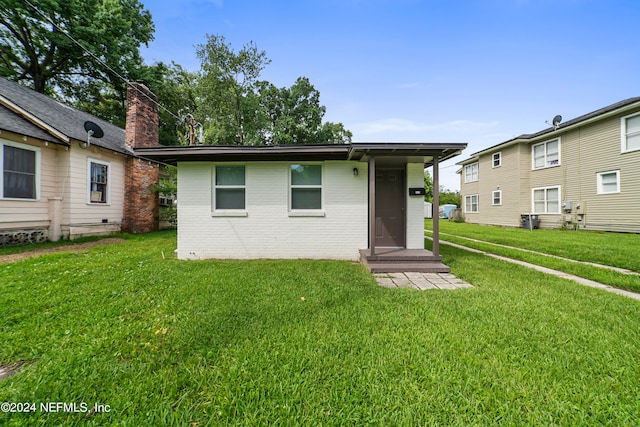 rear view of property with a lawn