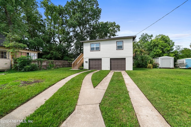 view of front of home with a garage, a storage unit, and a front lawn