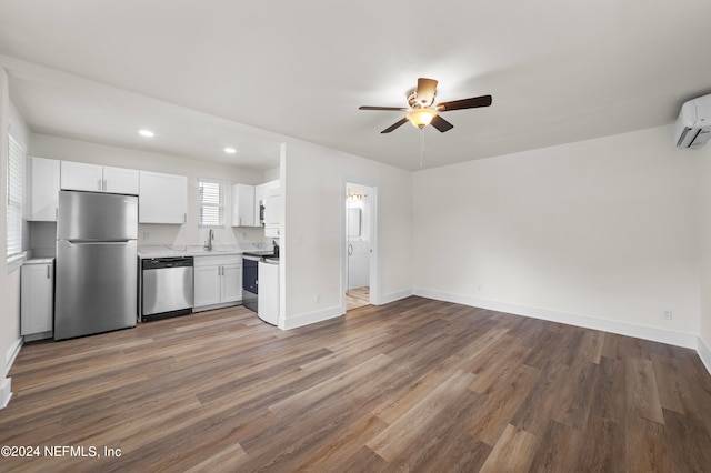 kitchen with white cabinets, ceiling fan, stainless steel appliances, hardwood / wood-style floors, and sink