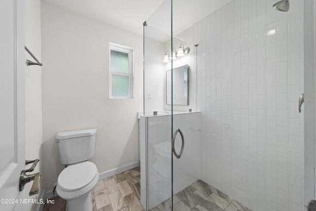 bathroom featuring toilet, wood-type flooring, and an enclosed shower