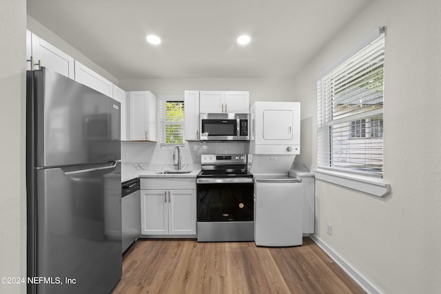 kitchen with appliances with stainless steel finishes, white cabinetry, and wood-type flooring