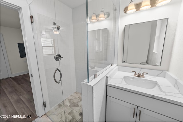 bathroom with a tile shower, vanity, ceiling fan, and hardwood / wood-style floors