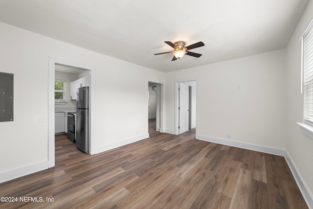 empty room with ceiling fan, hardwood / wood-style flooring, and electric panel