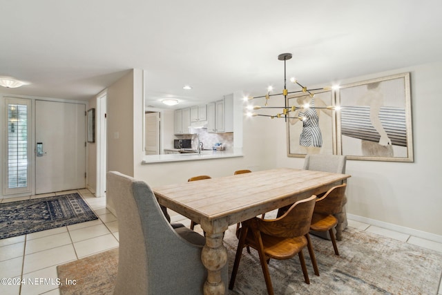 tiled dining area featuring a chandelier