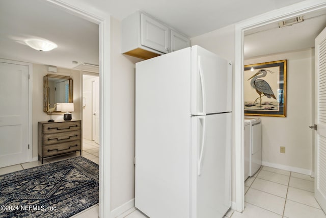 kitchen with white cabinetry, white refrigerator, light tile patterned floors, and independent washer and dryer