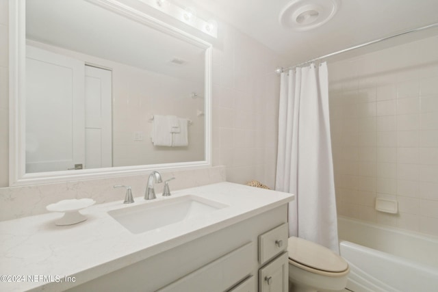 full bathroom with toilet, vanity, and shower / tub combo