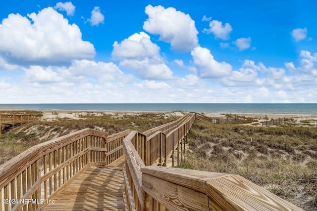 view of home's community with a water view and a beach view