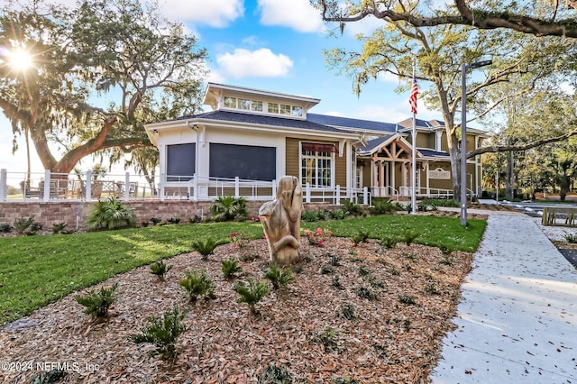 view of front facade featuring a front lawn and a sunroom