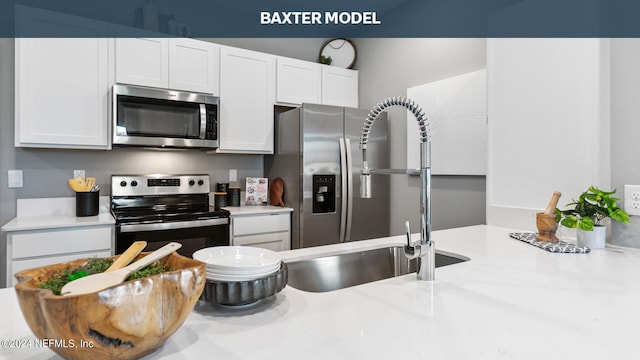 kitchen with white cabinets, stainless steel appliances, and light countertops