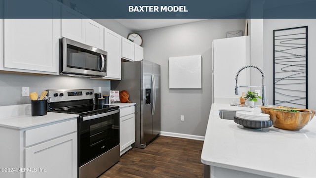 kitchen featuring dark wood-type flooring, a sink, stainless steel appliances, white cabinets, and light countertops