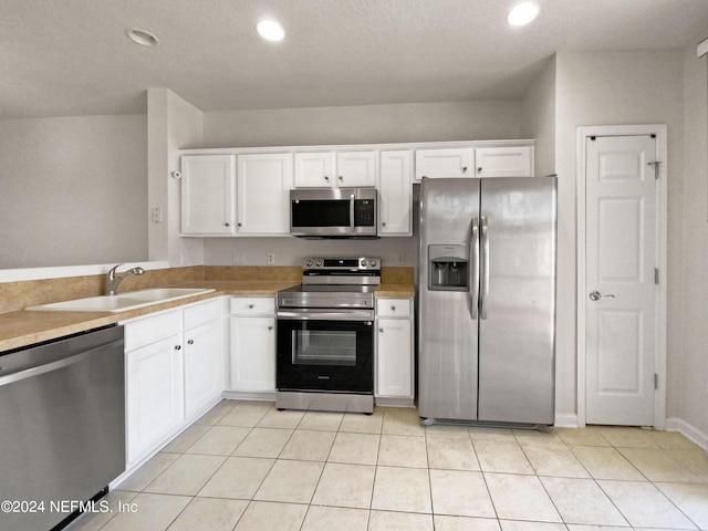 kitchen with white cabinetry, sink, light tile patterned floors, and appliances with stainless steel finishes