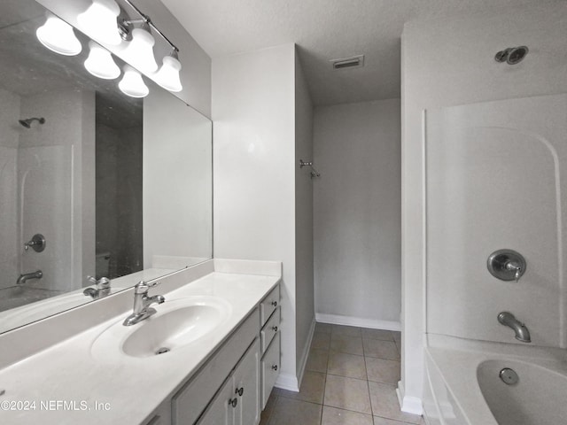 bathroom featuring tile patterned flooring, vanity, a textured ceiling, and washtub / shower combination