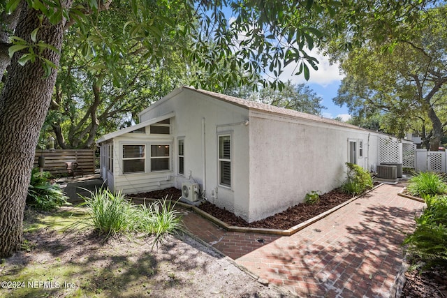305 Garden Ln, Atlantic Beach, FL 32233 - view of front facade with ac unit, stucco siding, central AC, and fence