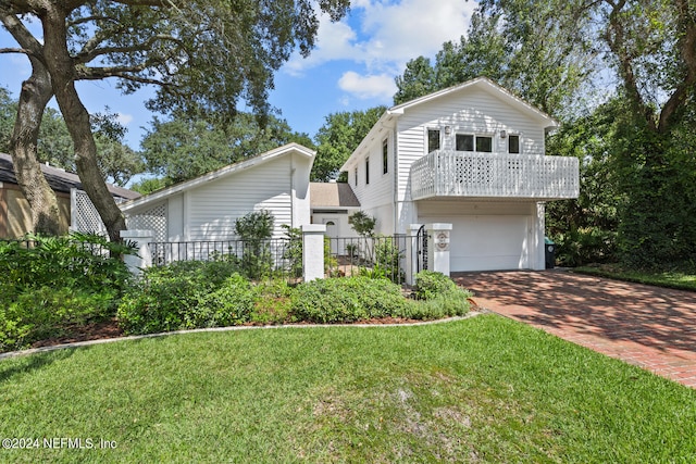 view of front of house with a balcony, a garage, and a front lawn