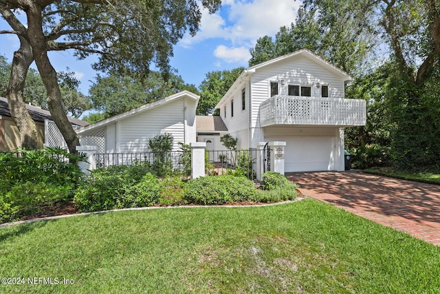 305 Garden Ln, Atlantic Beach, FL 32233 - view of front facade with decorative driveway, a front yard, an attached garage, and fence