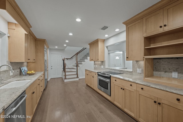 kitchen with backsplash, stainless steel appliances, light hardwood / wood-style floors, and sink