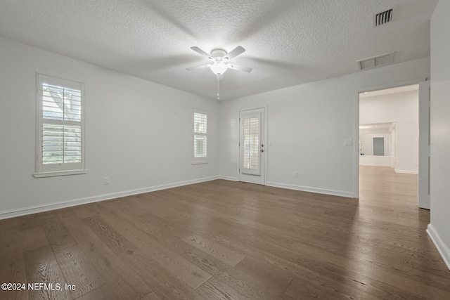 spare room featuring ceiling fan, dark wood-type flooring, and a textured ceiling