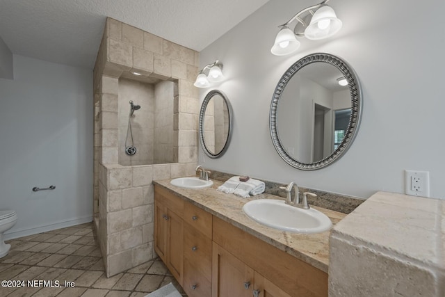 305 Garden Ln, Atlantic Beach, FL 32233 - bathroom featuring a sink, tiled shower, a textured ceiling, and double vanity