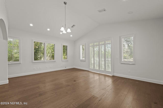 unfurnished room featuring lofted ceiling, a wealth of natural light, a chandelier, and dark hardwood / wood-style floors