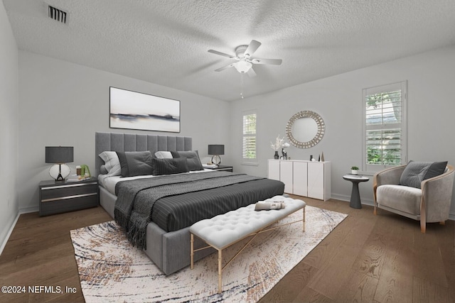 bedroom with multiple windows, ceiling fan, dark wood-type flooring, and a textured ceiling