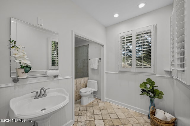 bathroom with a wealth of natural light, sink, and toilet