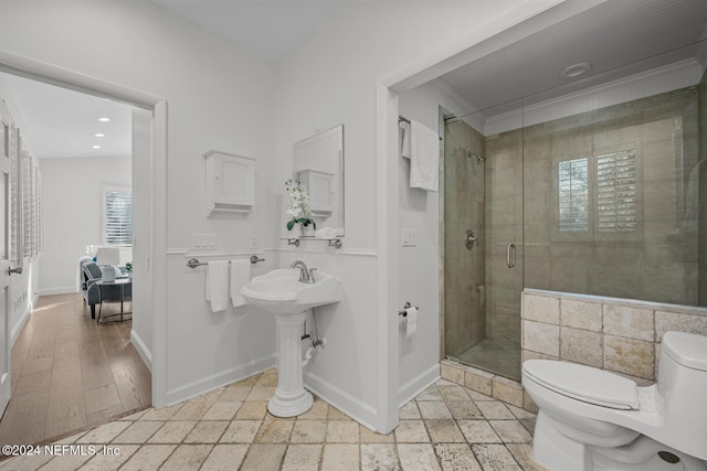 bathroom with hardwood / wood-style floors, toilet, an enclosed shower, and ornamental molding