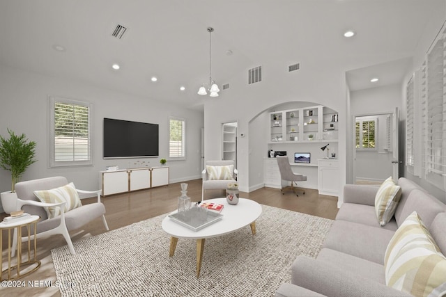 living room featuring a wealth of natural light, built in desk, and wood-type flooring