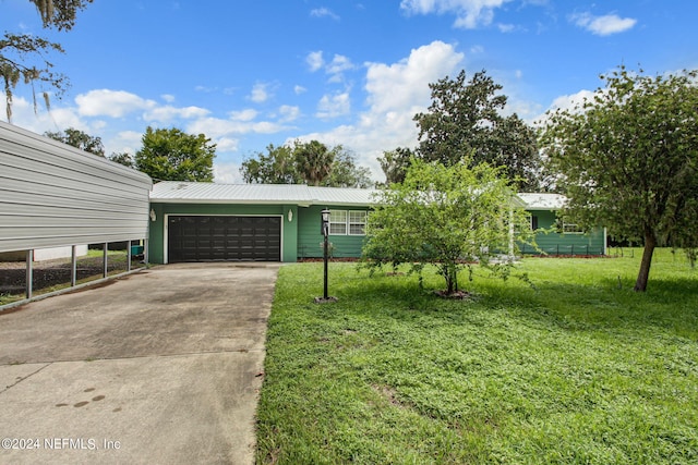 view of front of house featuring driveway, metal roof, a garage, and a front lawn