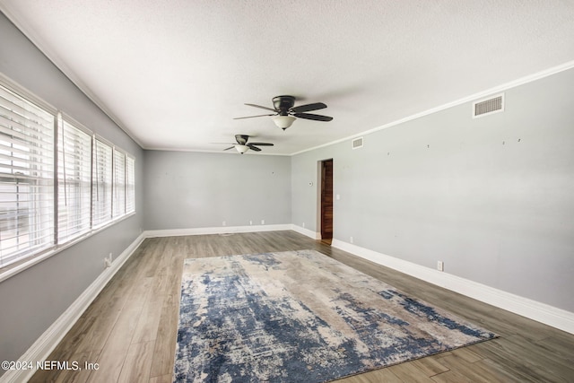 unfurnished room with visible vents, crown molding, and a textured ceiling