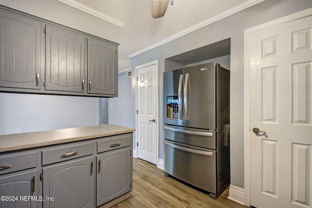 kitchen featuring gray cabinetry, ornamental molding, wood finished floors, and stainless steel fridge with ice dispenser